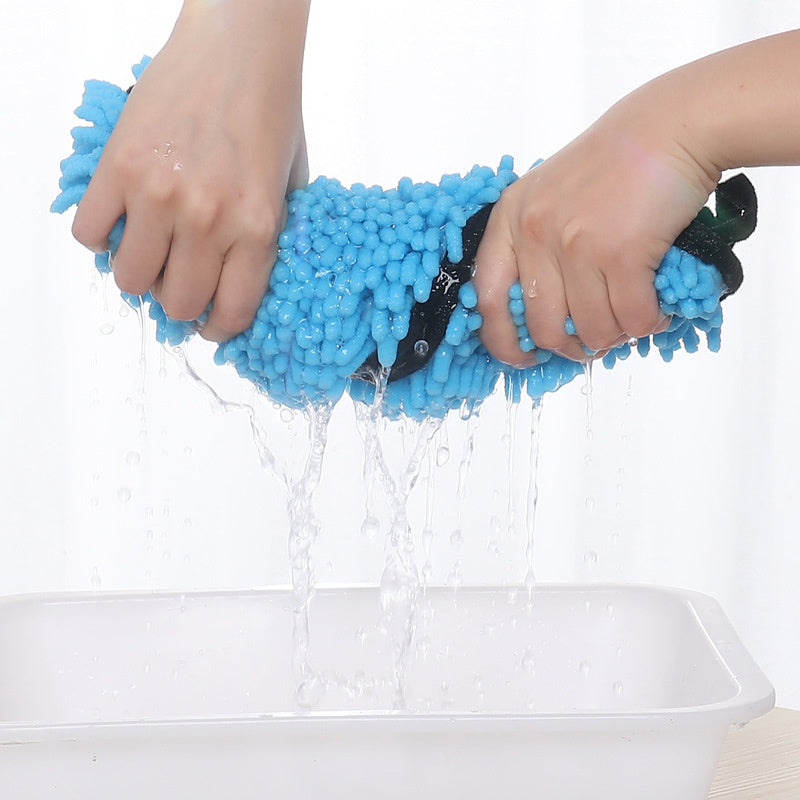 Blue scrubber being rinsed under running water with a white background