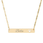 Gold necklace with 'Bella' engraving and paw print on a white background